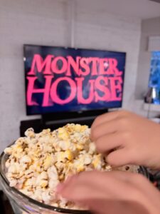 Kids grabbing Spooky Cheddar popcorn during a Monster House family movie night.