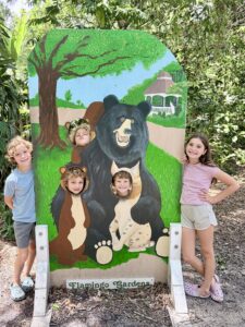 Kids posing at the bear photo cutout at Flamingo Gardens wildlife sanctuary in Davie Florida
