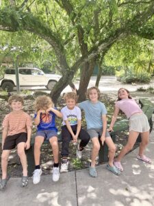 Homeschool kids sitting together under giant oak trees at Flamingo Gardens Davie Florida