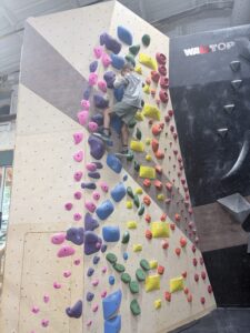 First-time climber on a bouldering wall with pink holds